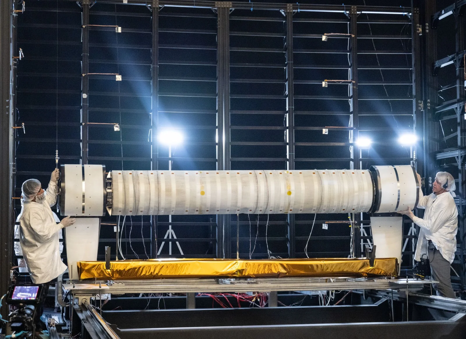 Technicians work beside Astrobotic’s rolled solar array prototype inside NASA Johnson’s large thermal-vacuum chamber.